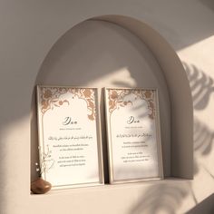 two framed wedding cards sitting on top of a shelf