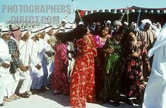 some people are standing in front of a tent and one person is taking a picture