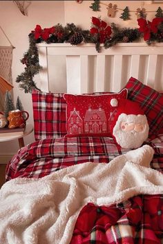 a bed covered in plaid sheets and pillows with a santa clause pillow on top of it