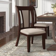 a dining room table with two chairs and a fire place