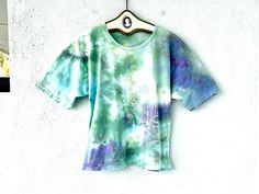 Vintage Hawaiian tshirt whimsically tie dyed with flowers blooming from the bottom up! S p e c i f i c s . . .  Label: --  Tagged Size: -- Approx. Fit: M - XL depending on fit pref Color: Greens // Purples // White Material: Soft perfectly worn in Cotton Tshirt Material  Condition: Overall in Amazing Vintage Condition (The best vintage not new but looks like you've owed this for years, condition) Tie Dye Hippie T-shirt For Spring, Hand Dyed Graphic Tee For Spring, Hippie Hand Dyed Short Sleeve Tops, Spring Graphic Tee Hand Dyed, Hippie Tie-dye Short Sleeve Tops, Hippie Tie Dye Short Sleeve Top, Spring Hippie Hand-dyed T-shirt, Spring Hippie Hand Dyed Tops, Artsy Design