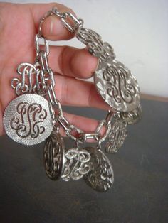 Decadencefashion Vintage Jewelry 1970s Monogram Charm Bracelet Silver Metal Chunky Heavy Charms packaged with white jewelry box Measurements Length - 7" Charms range in size 3/4" to 1 1/8" to 1 1/4" Materials - Silver Metal Condition - Excellent True Vintage *wear a little bit of history* XOXOXOXOXOXOXOXOXOXOXOXOXOXO Instagram: decadence@decadencefashion Decadencefashion: Curated by searching out and carefully selecting fabulous vintage items in excellent condition. Specializing in vintage fashion from the 1970s, 1980s, 1990s, 2000s *Reminder Note Please keep in mind, all of my items are 100% authentic vintage. This means they are not new and may show natural signs of wear and age. I do my very best to make note of any and all flaws in the item description but there may be something tiny t Retro Silver Bracelet Jewelry, Retro Silver Bracelet, Retro Metal Jewelry For Gifts, Retro Silver Metal Jewelry, Retro Metal Jewelry For Gift, Vintage Charm Bracelet For Party, Elegant Metal Charm Bracelet For Collectors, Retro Silver Jewelry For Anniversary, Elegant Metal Charm Bracelet Collectible