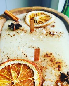 an orange cut in half sitting on top of a wooden tray next to cinnamon sticks