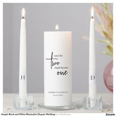 two white candles sitting next to each other with the words, and one candle on top