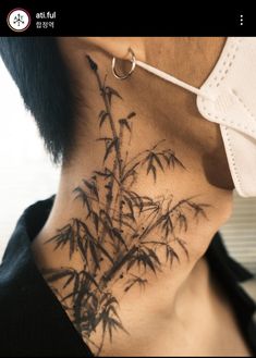 a woman with a tattoo on her neck and behind her ear is a bamboo tree