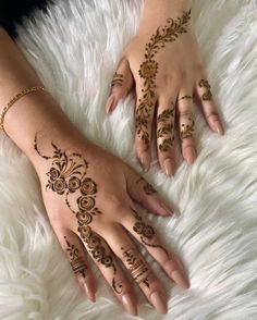 two hands with henna tattoos on them