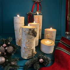 some candles are sitting on a table next to christmas decorations