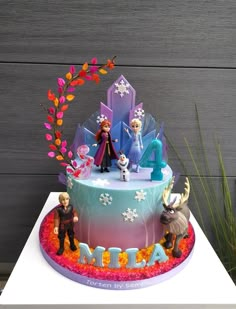 a frozen princess birthday cake with figurines on top