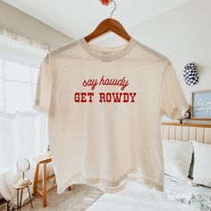 Say Howdy Get Rowdy Cropped Comfort Colors Shirt WOMEN'S COMFORT COLOR CROPPED BOXY TEE You can choose an oversize look or go with a regular fit. For an oversized cropped shirt fit, we recommend to size up by 2 - 3 sizes. If you are wanting a design change, please message the shop for approval - ANY design changes not approved by the shop will be cancelled SHIRT DETAILS - Comfort Colors® 3023 Women's Cropped Boxy Tee - 100% cotton, cropped, boxy fit - Runs true to size for a classic fit, if you Trending Tshirts Western, Women Country Concert Outfits, Cute Vinyl Shirts, Cricut Tee Shirt Ideas, Cricut Shirt Ideas Women, T-shirt Designs, Circuit Shirt Ideas, Funny T Shirt Ideas, Tee Shirt Outfit Ideas