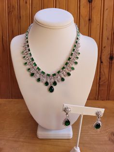 Emerald green colored crystal necklace and earring jewelry set.  Necklace is 18 inches non adjustable.  Green teardrop stones are .5 to 5 carats.  Square cut stones are 2mm to 3mm.  Center stone on earrings is 4 carats with clear crystal accents.  Earrings are 1.5 inches with a 1 inch drop.  Silver plated. Elegant Pear-shaped Emerald Necklace For Formal Occasions, Elegant Formal Pear-shaped Emerald Necklace, Luxury Emerald Pear-shaped Jewelry, Luxury Pear-shaped Emerald Jewelry, Elegant Pear-shaped Emerald Jewelry, Elegant Emerald Teardrop Necklace, Elegant Teardrop Emerald And Diamond Necklace, Drop Emerald Necklaces For Formal Occasions, Emerald Drop Necklace For Formal Occasions