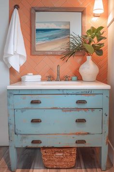 a bathroom with a blue dresser and white sink in front of an orange tiled wall