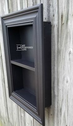 an empty shelf on the side of a wooden fence