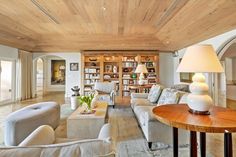 a living room filled with furniture and lots of bookshelves on top of it