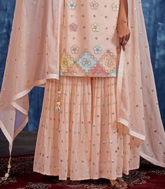 COLOR : Light Peach FABRIC : Top - Georgette, Bottom - Georgette, Dupatta - Georgette WORK : Resham Embroidery, Hand Work, Sequins, Motifs, Tassels, Lace Border OCCASION : Wedding, Reception, Party Wear, Festival READY-TO-WEAR : No STITCHING : Available as semi-stitched fabric, can be stitched using standard size option (+$20). Note: There might be a slight color variation due to lighting and flash used during photoshoot. The bright shade seen is the best closer view of fabric's color. Embroidered Peach Traditional Wear For Festive Occasions, Unstitched Peach Sets In Traditional Drape, Peach Zari Work Sets, Festive Embroidered Peach Sets, Fitted Multicolor Palazzo Set With Zari Work, Unstitched Peach Sets For Festive Occasion, Embroidered Peach Georgette Dupatta, Festive Unstitched Peach Sets, Festive Peach Zari Work Sets