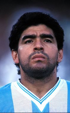 a close up of a soccer player wearing a blue and white uniform looking at the camera