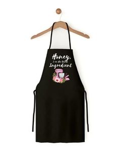 an apron that says honey i'm so important on the front, and pink flowers in