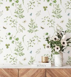 a vase filled with flowers sitting on top of a wooden dresser next to a wall