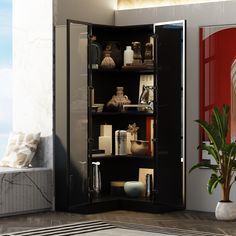 a room with a large black cabinet filled with vases and other items next to a potted plant