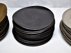 a stack of black and white plates sitting next to each other on top of a table