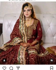 a woman sitting on top of a white couch wearing a red and gold wedding dress