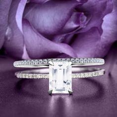 a white gold ring with an emerald cut diamond and pave set diamonds on the band