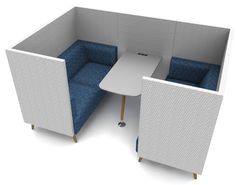 an office cubicle with two blue chairs and a white table in the corner area