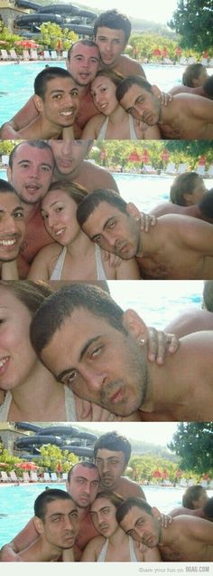 two men and one woman are hugging in front of a pool while another man is taking a selfie