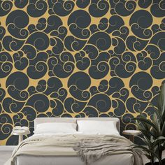 a bed sitting in front of a black and gold wallpaper with swirls on it