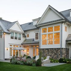 a large white house sitting on top of a lush green field