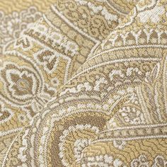 close up view of an intricate gold and white paisley print fabric