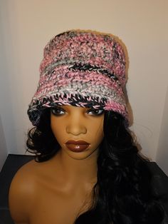 a mannequin head wearing a pink and black crochet hat