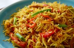 a blue plate topped with noodles and vegetables