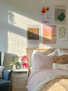 a bed sitting in a bedroom next to a blue chair and window with pictures on the wall