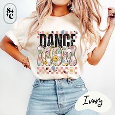 "DANCE MOM" Retro Shirt - Celebrate Your Dance Mom Era! Get ready to show support in style with our "DANCE MOM" Retro Checkerboard Shirt! This fun tee is adorned with lots of retro details like checkerboards, lightning bolts, flowers, happy faces, and stars, making it the perfect gift for moms who rock the dance mom era. Designed with comfort in mind, this Dance Mom Shirt is made on soft Comfort Colors fabric for a cozy feel all day long. Whether you're a team mom cheering on your dancers or celebrating a recital, this shirt is a must-have addition to your wardrobe. Embrace your role as a dancer mama with our retro Comfort Colors tee and let your love for dance shine bright. It's time to show off your dance mom spirit with this fun and stylish competition tee! 💕Proudly printed on Comfort Casual T-shirt With Letter Print For Dance Class, Casual Graphic Print T-shirt For Dance Class, Casual Graphic Print T-shirt For Dance, Summer Dance Class Crew Neck T-shirt, Hip Hop T-shirt With Letter Print For Dance Class, Hip Hop Letter Print T-shirt For Dance Class, Summer Crew Neck T-shirt For Dance Class, Casual Dance Shirt With Graphic Print, Casual Tops For Summer Dance Class