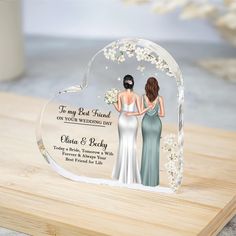 an acrylic heart with two brides holding hands