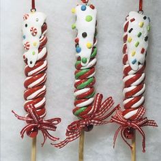 three candy lollipops are wrapped in red, white and green icing