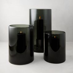 three black candle holders sitting next to each other