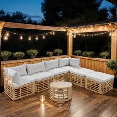 an outdoor seating area with string lights and wooden flooring is lit up at night