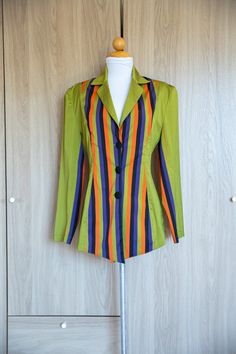 D E T A I L S * avant garde fitted 2000s lime green striped blazer  * tapered waist  * vibrant orange, purple, green and black warped vertical stripes down center of jacket and also appears on the inner sleeves * three black covered buttons * Light shoulder pads for structured look  * collared  * light weight, medium silk weave, very smooth and silky with a great sheen to it * made of silk * no label made in France A NOTE ON STYLE: Purchased this gorgeous jacket while in the French Riviera. No label but extremely well made and chic. Perfect to dress up or throw on and go casually. M E A S U R E M E N T S shoulder: 17" Sleeve: 23" waist: 14.5" length: 30" C O N D I T I O N In very good condition. Multicolor Long Sleeve Office Blazer, Fitted Blazer With Vertical Stripes And Long Sleeves, Fitted Long Sleeve Blazer With Vertical Stripes, Retro Green Blazer For Spring, Fitted Vertical Stripes Spring Blazer, Spring Fitted Blazer With Vertical Stripes, Fitted Spring Blazer With Vertical Stripes, Fitted Blazer With Vertical Stripes For Spring, Office Blazer With Vertical Stripes And Long Sleeves