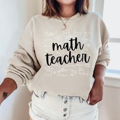 The "Math Teacher Sweatshirt" is a sturdy and warm sweatshirt bound to keep you warm in the colder months. A pre-shrunk, classic fit sweater made with love for you & your loved ones! Sweatshirt Details: * Gildan sweatshirt - unisex fit * 50% cotton, 50% polyester * Pre-shrunk * Classic fit with no center crease * 1x1 athletic rib knit collar with spandex * Air-jet spun yarn with a soft feel and reduced pilling * Double-needle stitched collar, shoulders, armholes, cuffs, and hem * Model is wearin Winter School Sweater With Letter Print, Long Sleeve Sweatshirt With Text Print For School, School Sweater With Letter Print And Long Sleeves, Winter School Sweatshirt With Letter Print, White Sweatshirt For Teacher Appreciation In Fall, Winter Letter Print Sweatshirt For School, Math Teacher Gifts, Math Teacher Shirts, Custom Teacher Gifts