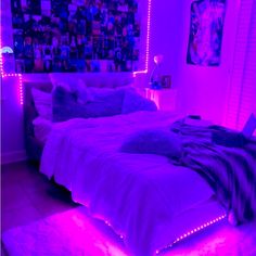 a bed with purple lights in a bedroom next to a window and pictures on the wall