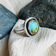 This ring features a beautifully unique bright blue piece of Kingman, AZ Turquoise. The Turquoise is set in a mini shadowbox .925 sterling silver handcrafted design and a hammered band to compliment the Boho style of the ring.  The ring is US size 6-6.25. (Just a bit larger than a true size 6.) IG: @wildrose.silver Please contact me for custom stones and sizing! Collectible Untreated Blue Turquoise Ring, Collectible Round Turquoise Ring, Handmade Blue Turquoise Ring For Collectors, One-of-a-kind Blue Turquoise Ring, One Of A Kind Blue Turquoise Ring, Blue Untreated Round Turquoise Ring, Southwestern Blue Rings For Gift, Southwestern Style Blue Rings For Gifts, Southwestern Style Blue Rings For Gift