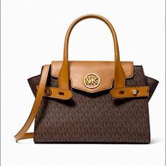 Michael Michael Kors Carmen Medium Logo And Faux Leather Belted Satchel. Brown. New With Tag Designer Faux Leather Bag With Double Handles, Designer Double Handle Faux Leather Shoulder Bag, Designer Faux Leather Satchel With Double Handle, Designer Faux Leather Tote Satchel, Designer Faux Leather Travel Bags, Chic Medium Bag With Gold-tone Hardware, Luxury Satchel With Leather Trim For Errands, Chic Brown Signature Coated Canvas Bag, Tan Leather Shoulder Bag With Leather Trim