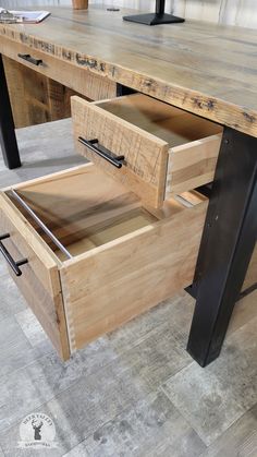 a wooden desk with two drawers on it and a black metal frame around the top