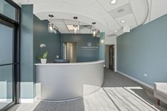 an office lobby with a curved counter and blue walls