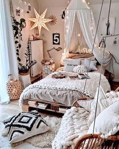 a bedroom with white bedding and lots of lights on the ceiling, hanging from strings