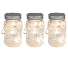 three mason jars with silver lids are shown