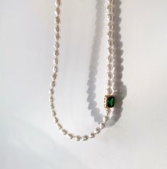 Handcrafted with care, this necklace features lustrous baroque pearls and vibrant emerald green gemstone, elegantly arranged to create a stunning contrast. The rich green hues of the emeralds complement the shimmering pearls, making this necklace a timeless and versatile accessory. Features: Handcrafted Elegant and versatile design Perfect for both casual and formal occasions Makes a thoughtful gift for someone special Specifications: Material: Emerald green zircon, cultured baroque pearls Lengt Elegant Green Pearl Drop Necklaces, Elegant Green Necklaces With Pearl Drop, Elegant Single Strand Green Emerald Necklace, Green Pearl Drop Necklace Gift, Green Pearl Drop Necklace For Gift, Elegant Green Pearl Necklace With Pendant, Green Pearl Pendant Necklace For May Birthstone, Green Necklaces With Pearl Pendant For May Birthstone, Elegant Green Single Strand Pearl Necklace