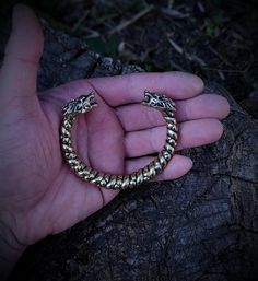 This is one special piece of metal, a Norse viking arm ring with wolf heads, a perfect present for any modern pagan warrior. Purchase it to surprise your man for the holidays, or get one of these for yourself, you know you deserve it. The bracelet is made out of bronze, hence the golden color. It is cast as a single piece of metal, so it is very sturdy and durable, created out of a special alloy that is resistant to any corrosion and color change. The size can be slightly corrected to better acc Viking Style Handmade Gold Jewelry, Handmade Viking Gold Jewelry, Handmade Viking Style Gold Jewelry, Viking Style Metal Bracelet For Gift, Bronze Viking Jewelry Collectible, Viking Style Bangle Bracelets, Viking Style Bracelet Jewelry Gift, Bronze Viking Jewelry For Ceremonial Occasions, Viking Style Metal Bracelet Jewelry