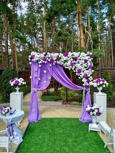 an outdoor wedding setup with purple and white flowers